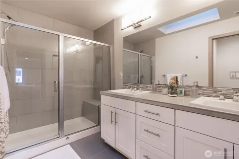 a bathroom with a shower sink and mirror