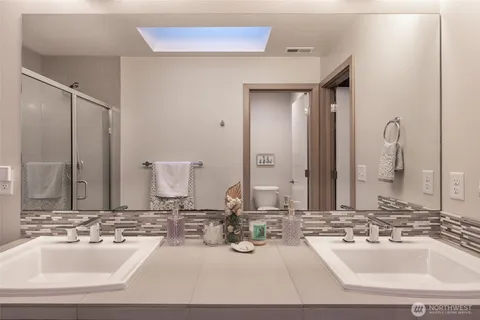 a bathroom with double vanity sinks and a mirror