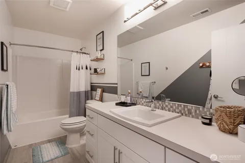 a bathroom with a sink toilet double vanity and shower
