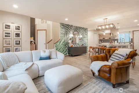 a living room with furniture kitchen view and a large window