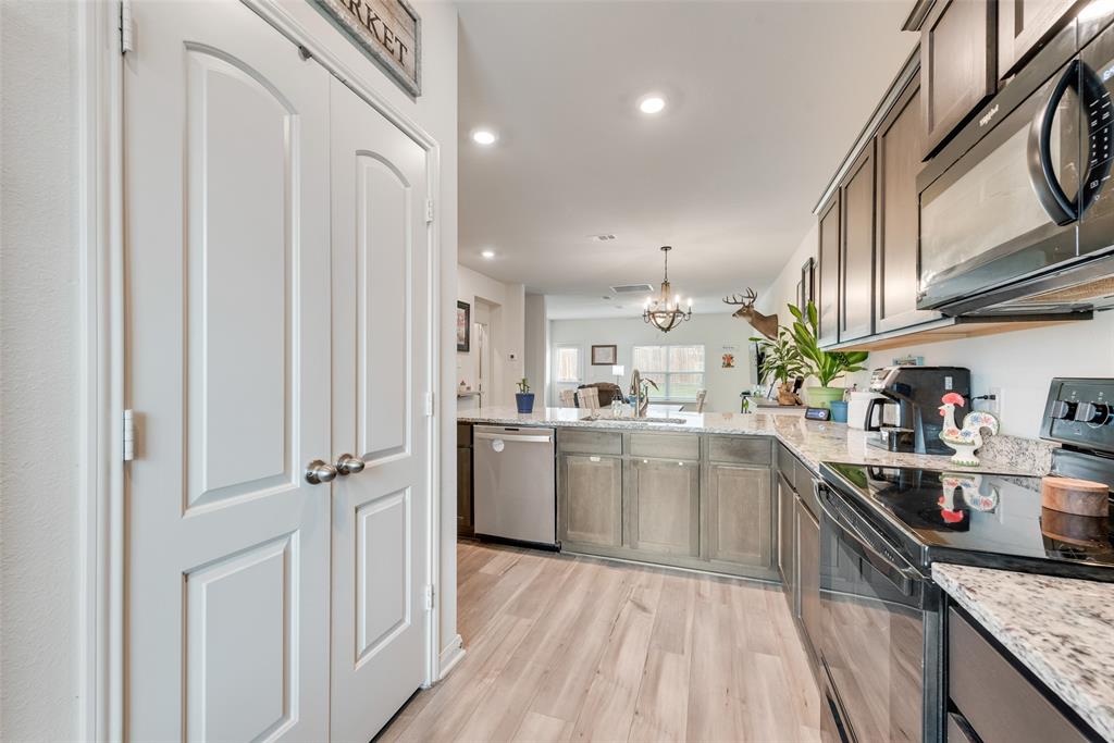 159 Bush Drive Venus, TX 76084 - Photo 11 of 24 a kitchen with cabinets and wooden floor