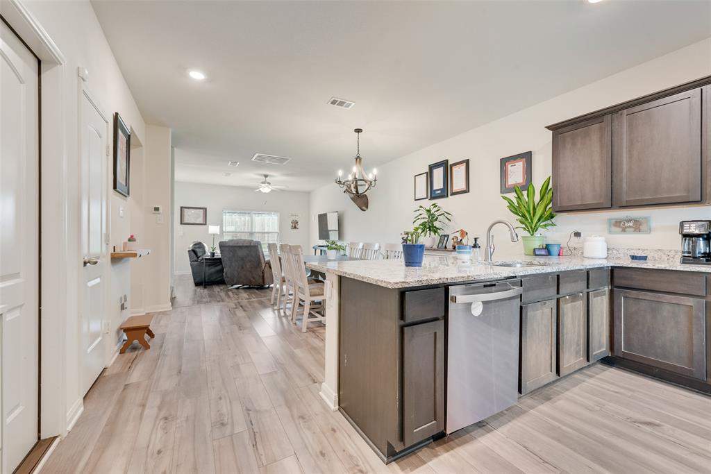 159 Bush Drive Venus, TX 76084 - Photo 24 of 24 a kitchen with kitchen island granite countertop a sink cabinets and wooden floor