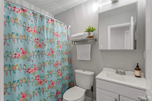a bathroom with a shower sink vanity and toilet