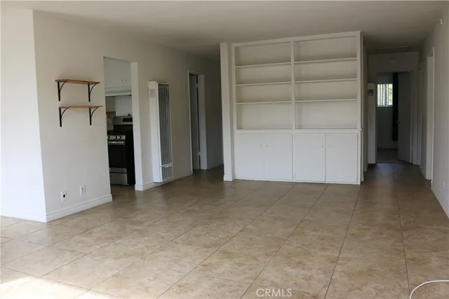 an empty room with closet and windows