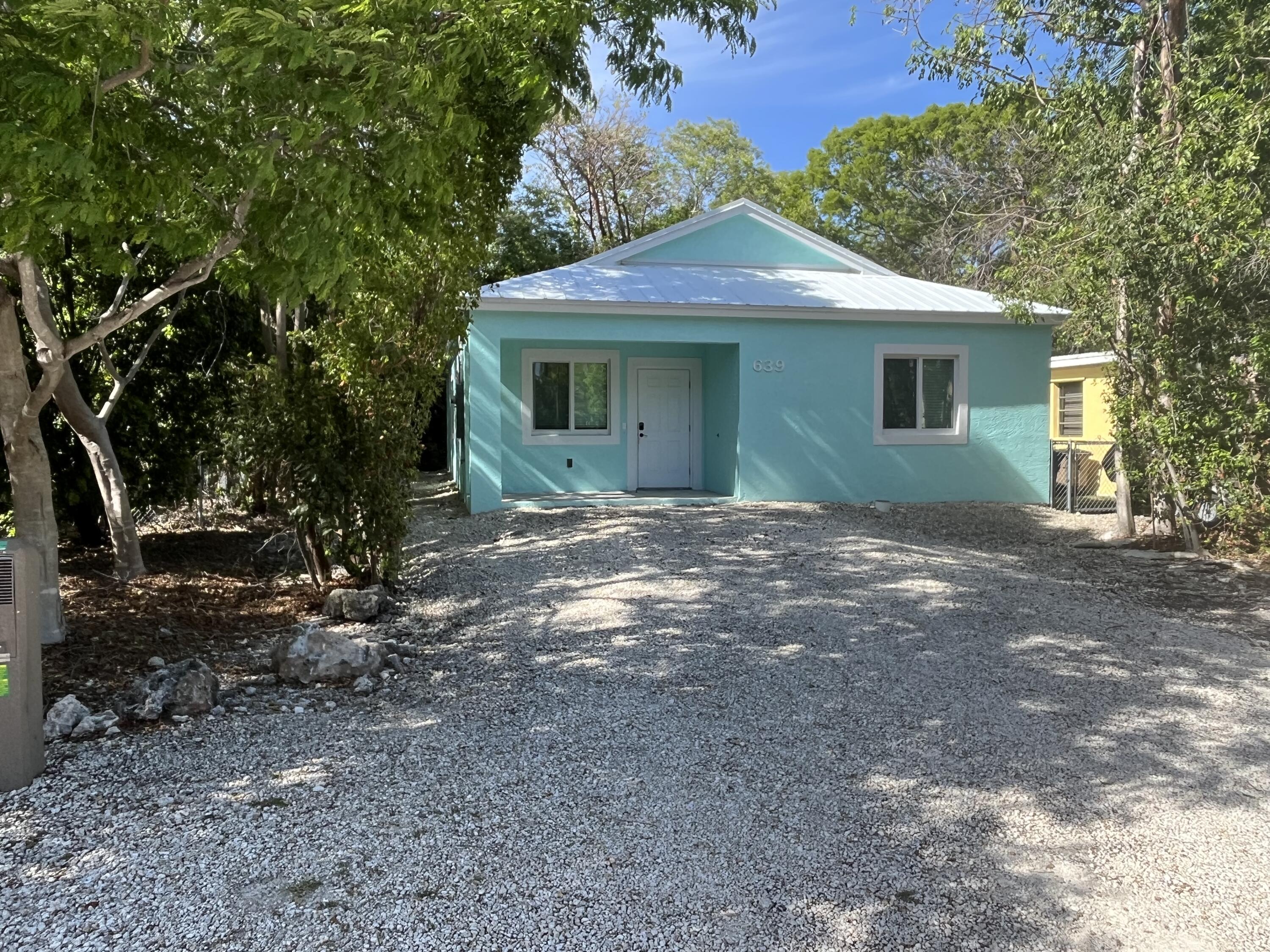 639 Cabrera Street Key Largo, FL 33037 - Photo 3 of 24 a front view of a house with a garden