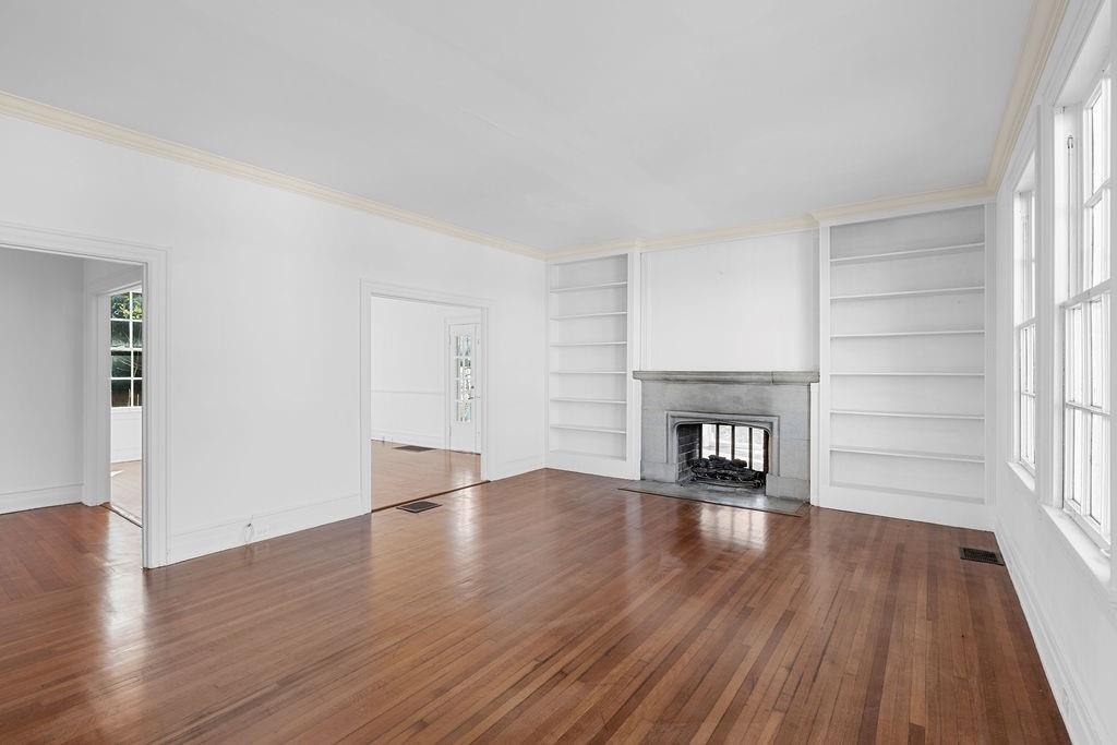 312 East 3rd Street Rome, GA 30161 - Photo 8 of 42 an empty room with wooden floor fireplace and windows