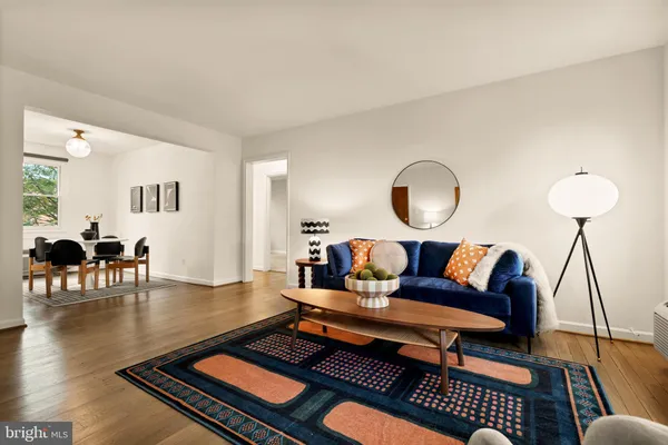 a living room with furniture a rug and a lamp