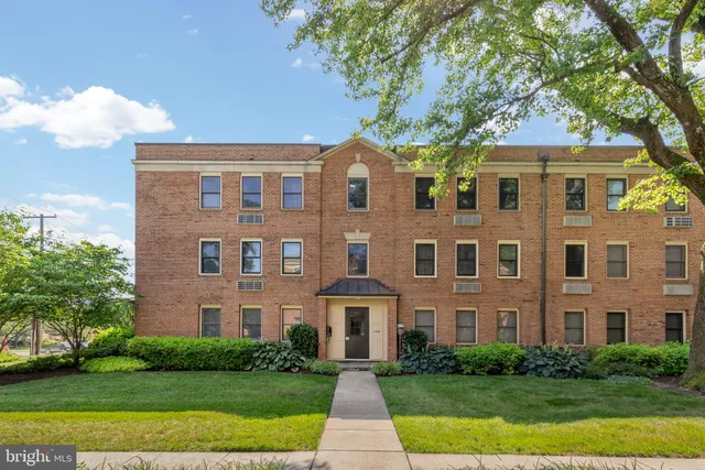 a front view of a brick house with a yard