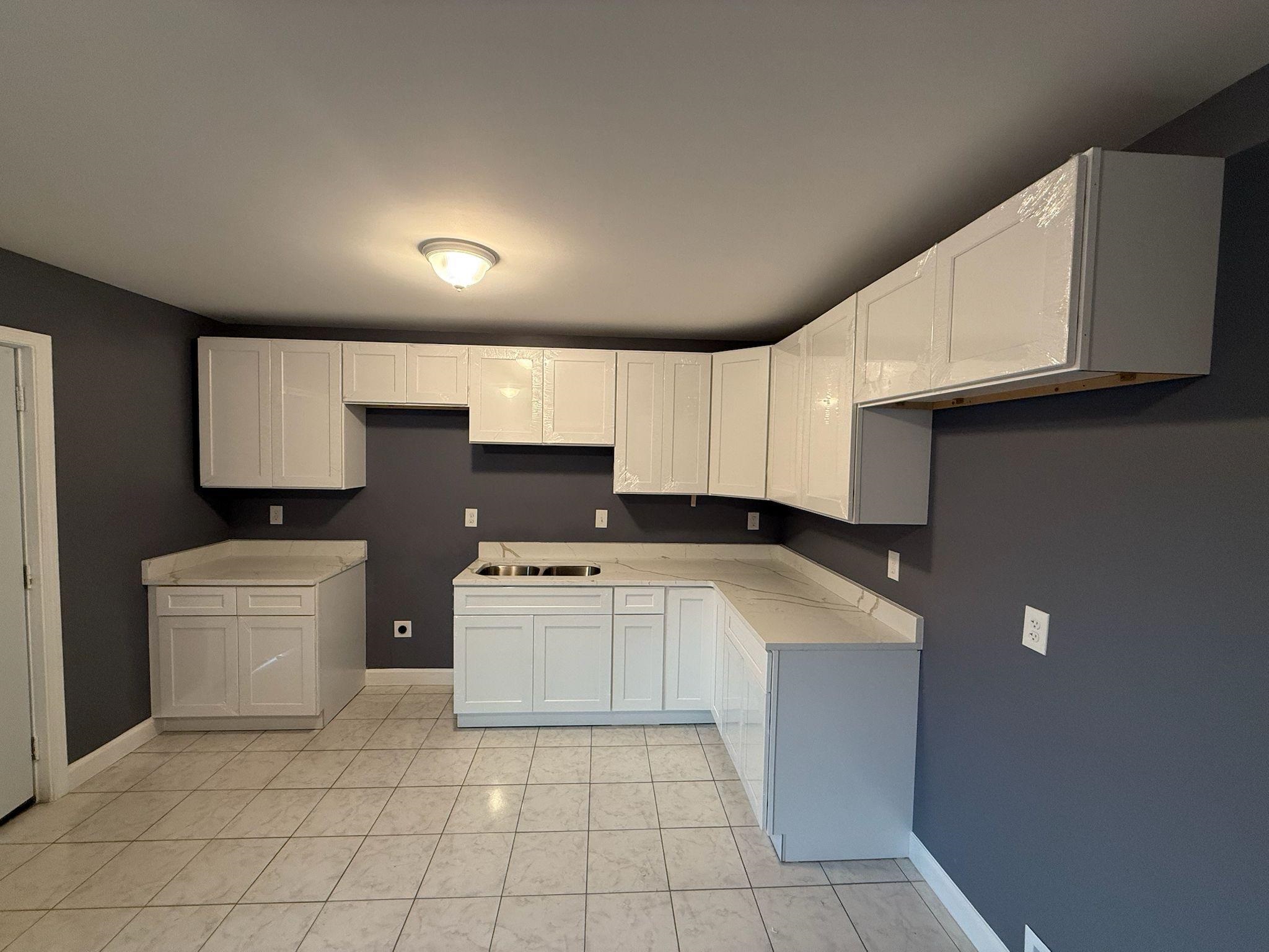 12 East Emory Road Memphis, TN 38109 - Photo 9 of 19 a kitchen with granite countertop a sink a stove top oven and white cabinets