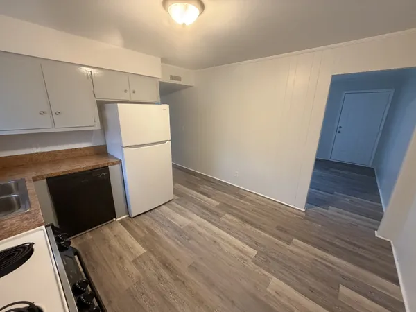 a bed room with a bed and a refrigerator