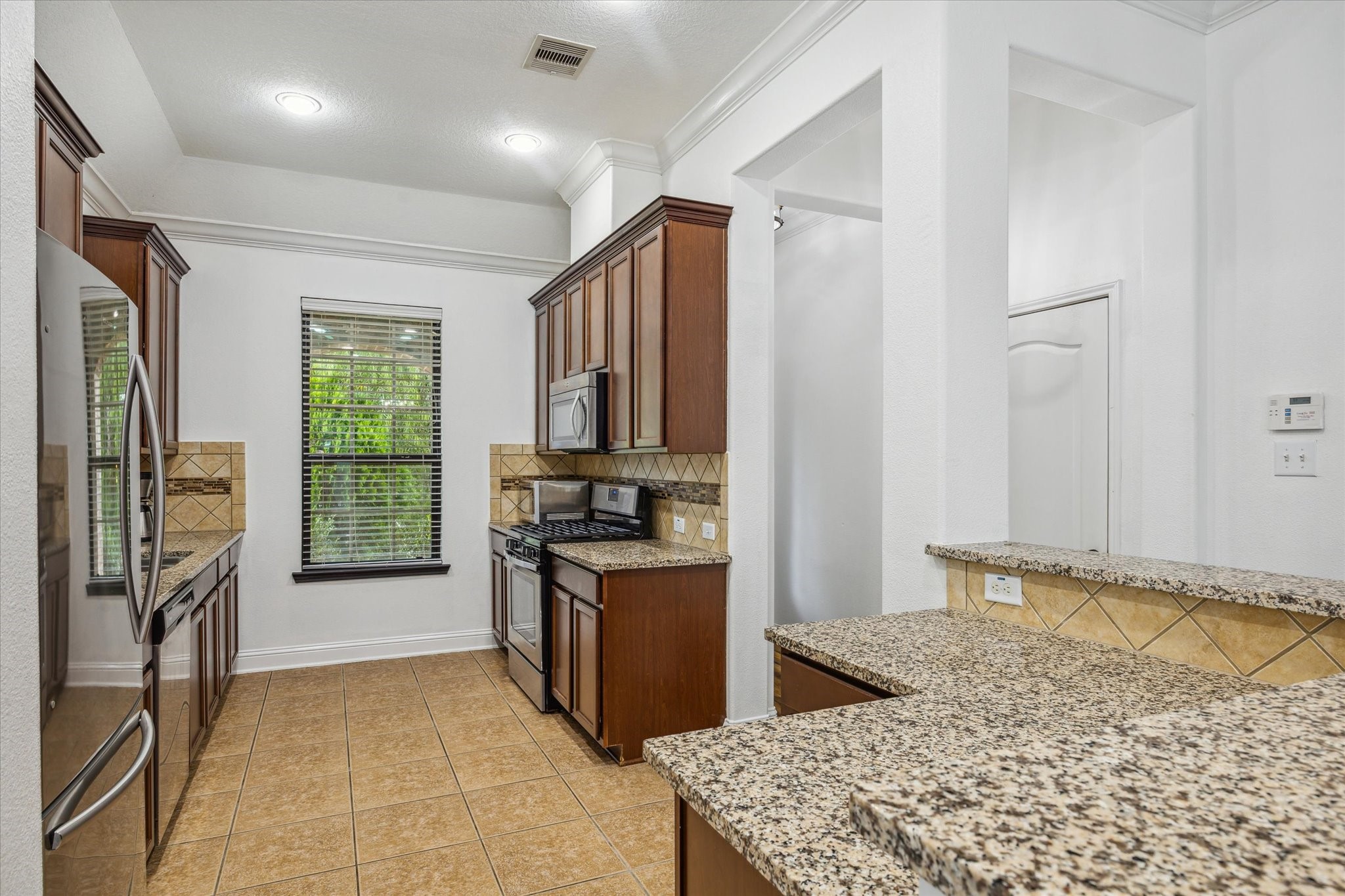 31 Butternut Grove Place Tomball, TX 77375 - Photo 4 of 25 a kitchen with stainless steel appliances granite countertop a refrigerator stove and oven