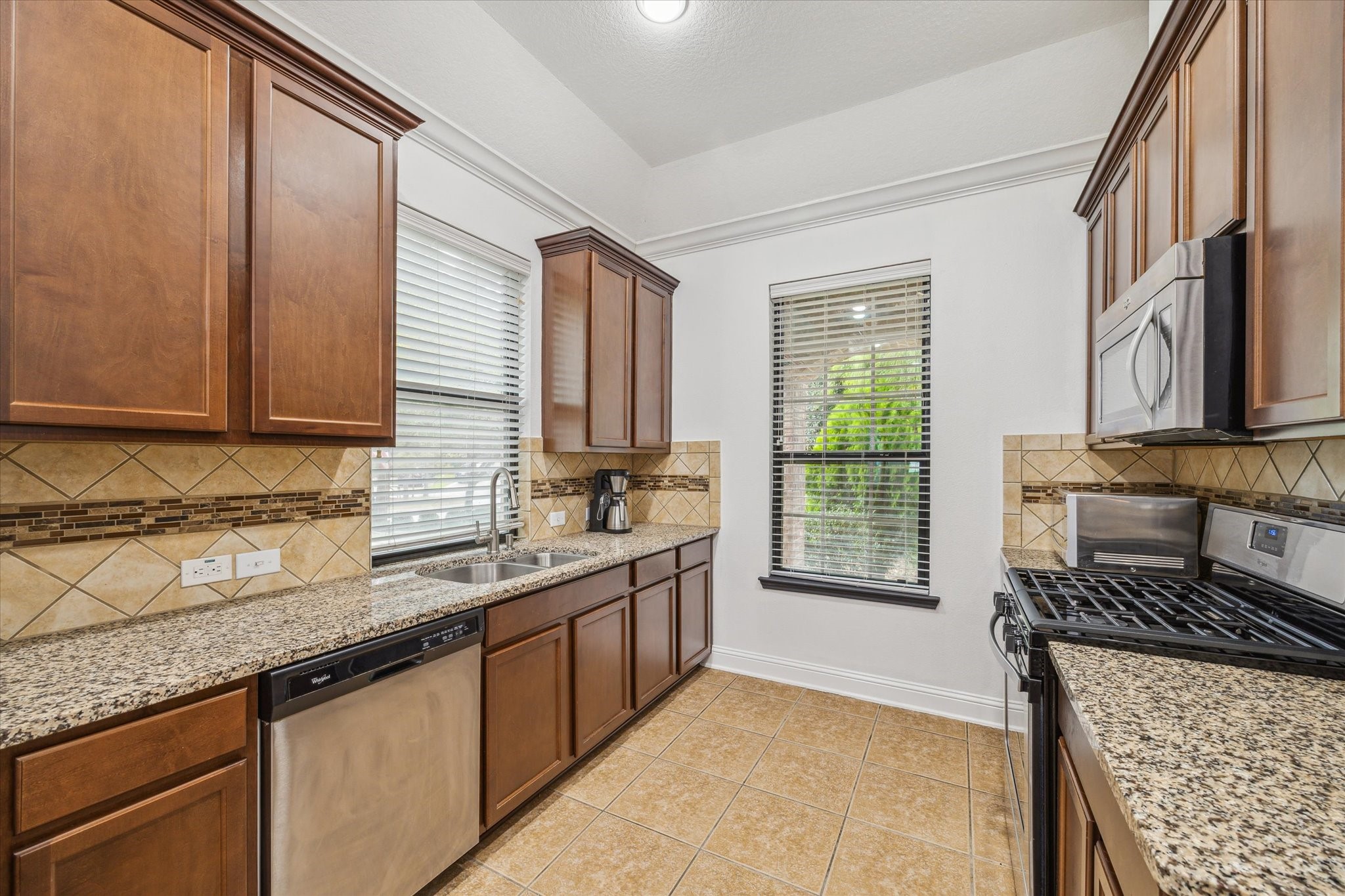 31 Butternut Grove Place Tomball, TX 77375 - Photo 5 of 25 a kitchen with stainless steel appliances granite countertop a sink stove and cabinets
