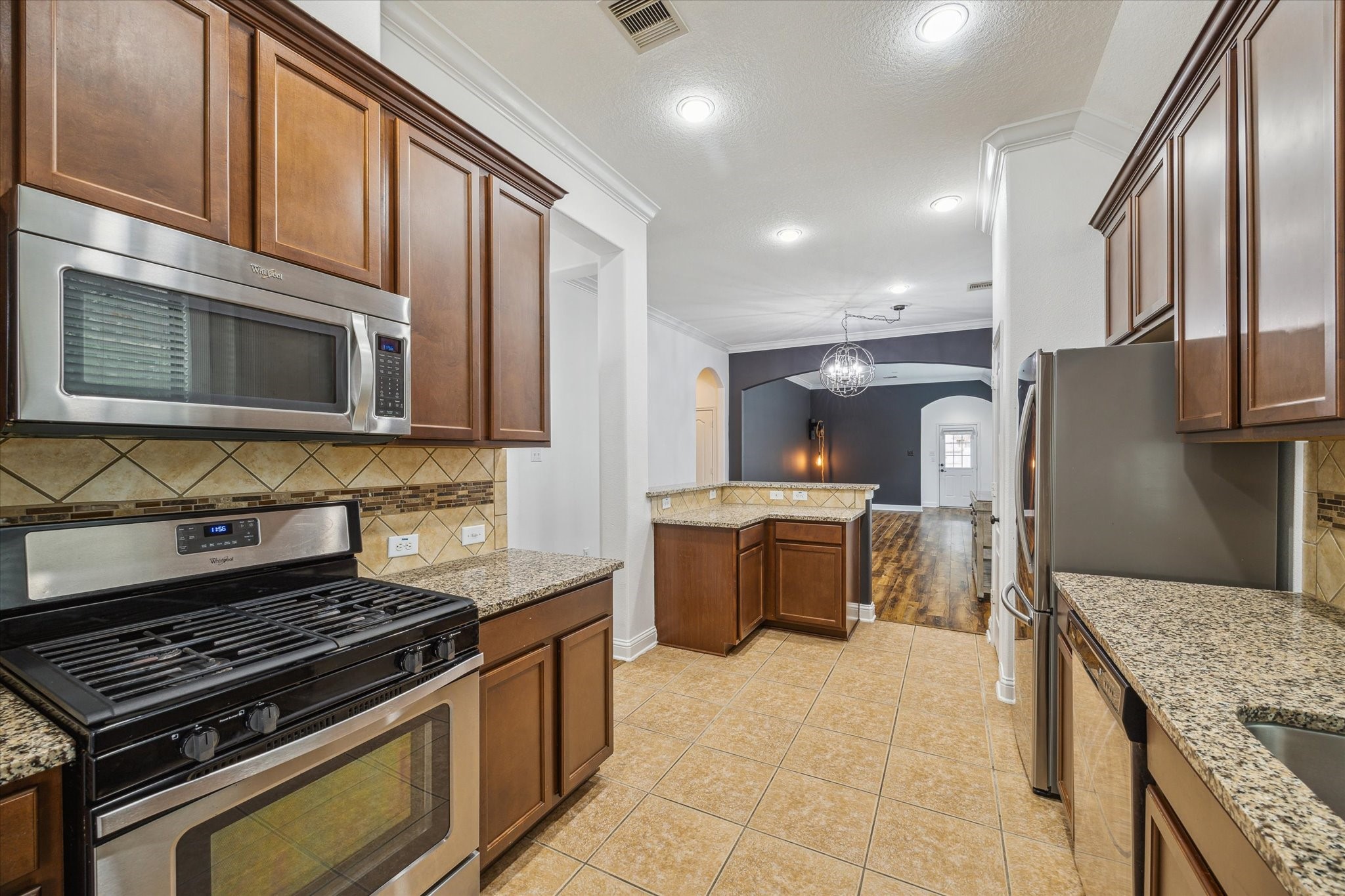 31 Butternut Grove Place Tomball, TX 77375 - Photo 6 of 25 a kitchen with stainless steel appliances granite countertop a stove top oven a sink dishwasher a refrigerator and cabinets with wooden floor