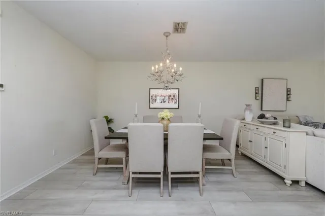a view of a dining room with furniture and chandelier