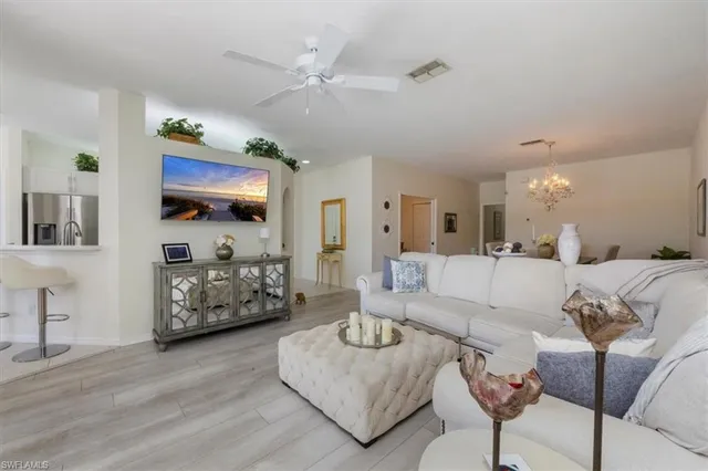a living room with furniture kitchen view and a flat screen tv