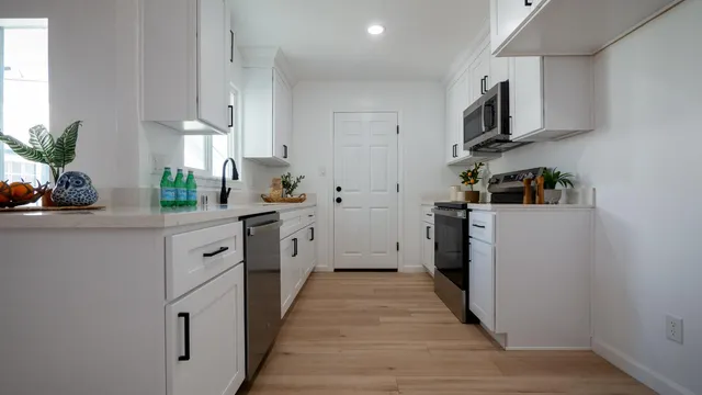 a kitchen with white cabinets and appliances