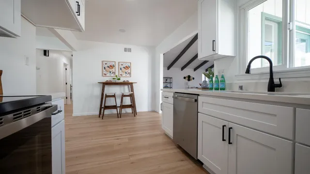 a kitchen with stainless steel appliances and wooden floor