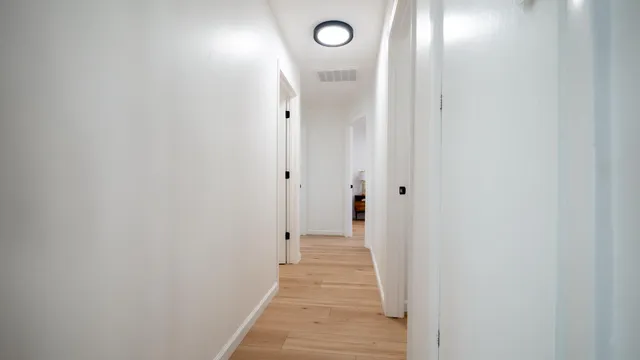 a view of a hallway with wooden floor