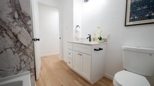 a bathroom with a sink mirror vanity and toilet