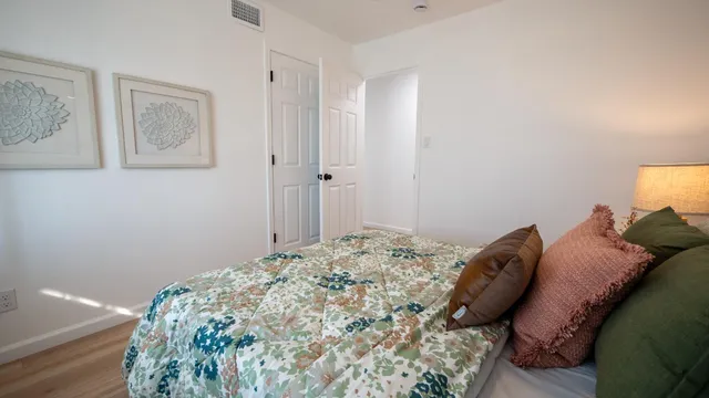 a bedroom with a bed and painting on the wall