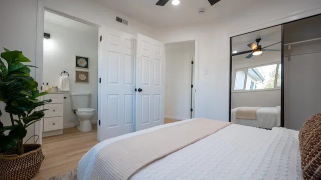 a bedroom with a bed and a potted plant