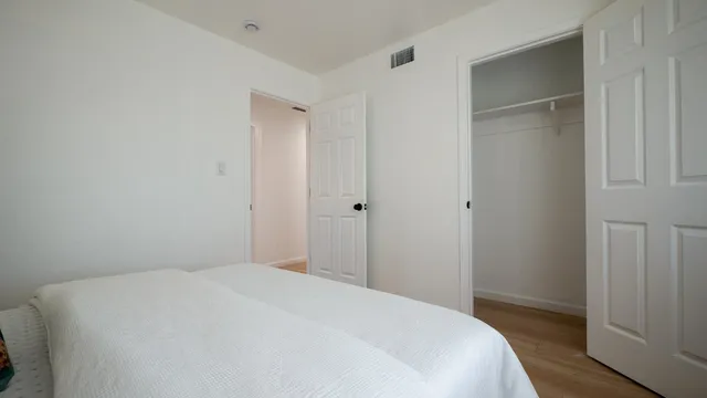 a bedroom with a bed and wooden floor