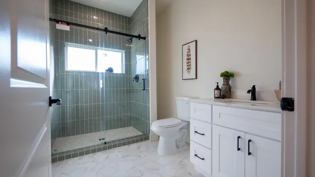 a bathroom with a shower sink vanity and toilet
