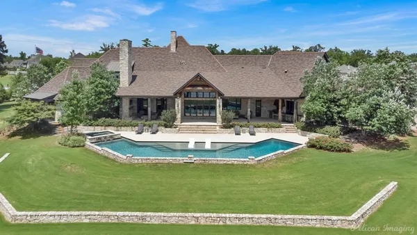 a view of a swimming pool with a patio and a yard