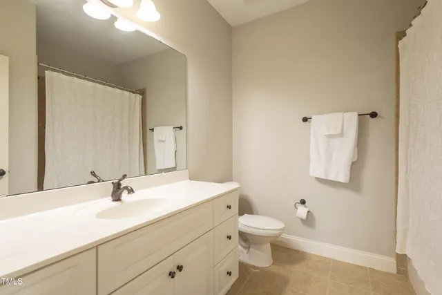 a bathroom with a granite countertop sink a toilet and a mirror