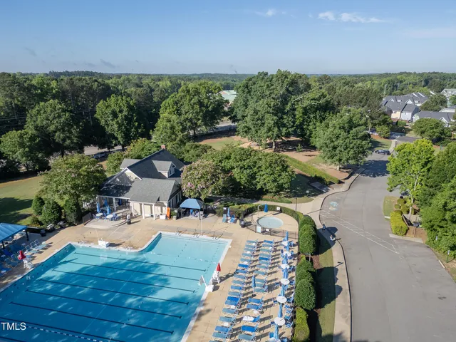an aerial view of a house with swimming pool and a yard