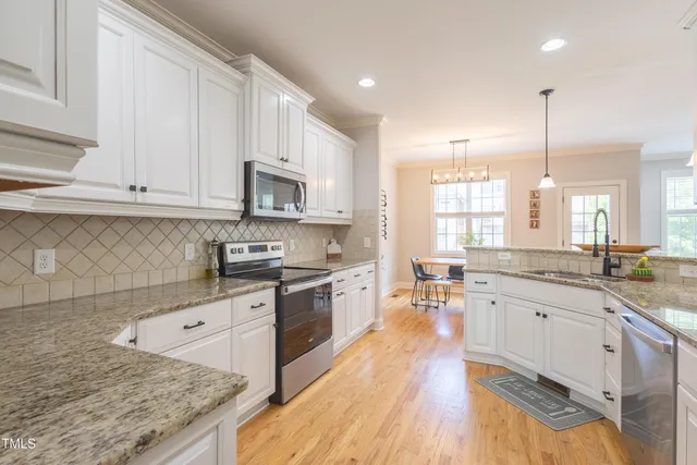 a large kitchen with stainless steel appliances granite countertop a stove and a sink