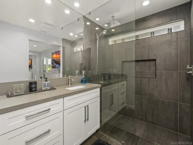 a bathroom with a shower a sink and a mirror