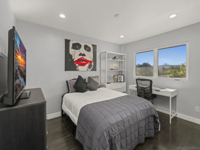 a bedroom with a bed and a flat screen tv