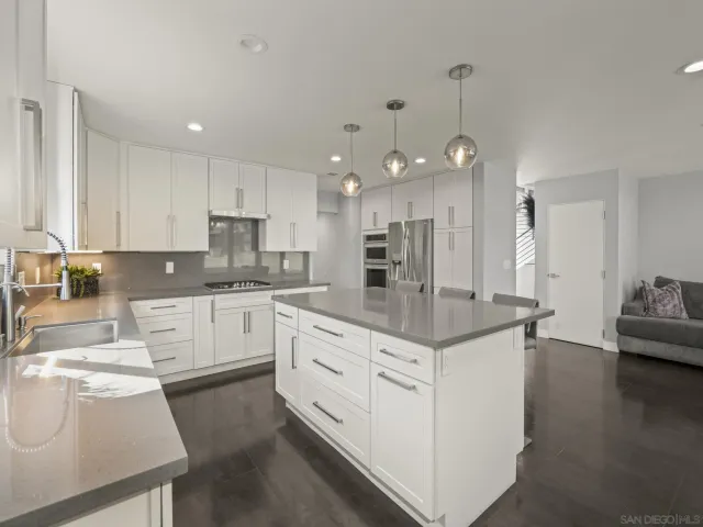a kitchen with kitchen island a sink stove and refrigerator