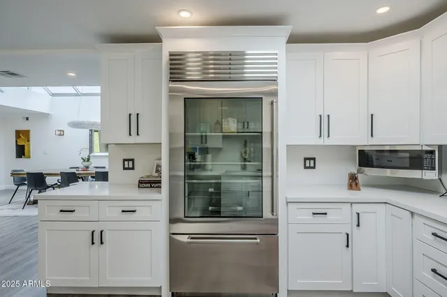a kitchen with white cabinets and sink