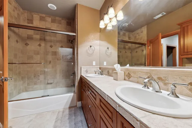 a bathroom with a sink a toilet a mirror and shower