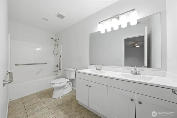 a spacious bathroom with a toilet a sink a mirror a bathtub and vanity