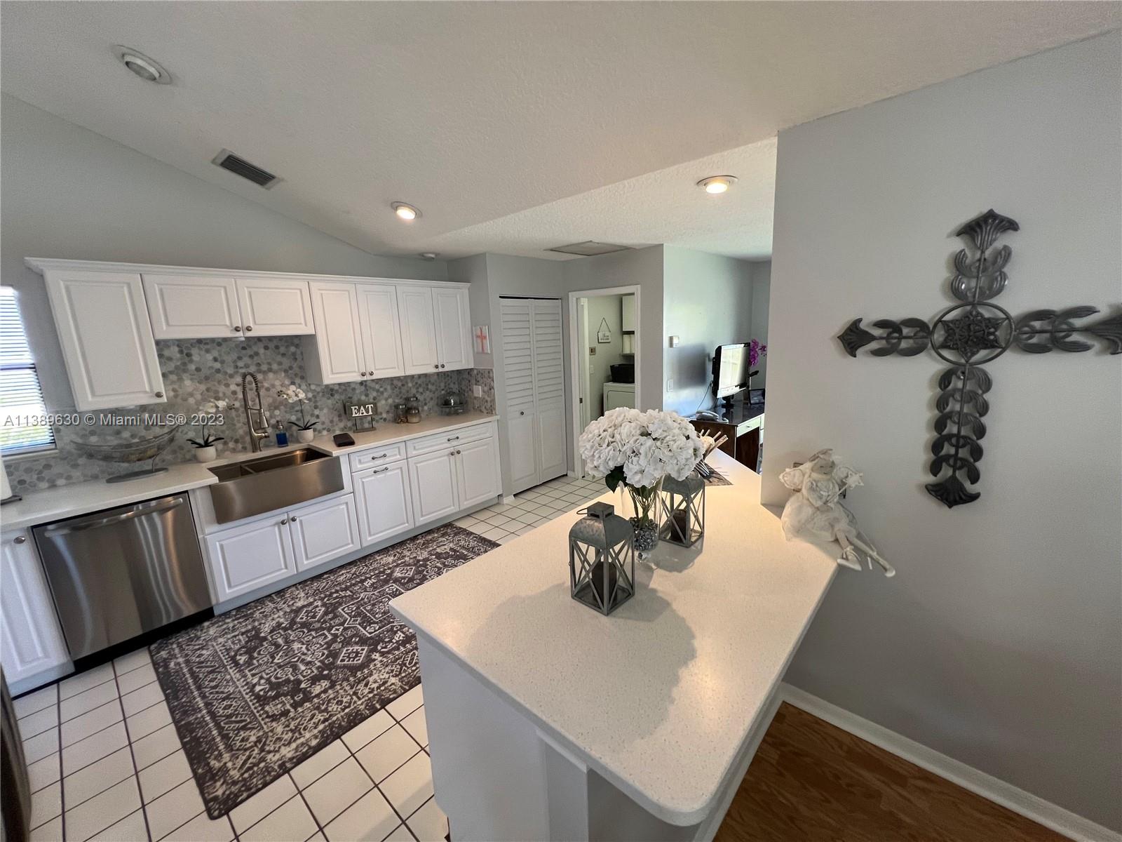 6159 Dimond Street Jupiter, FL 33458 - Photo 21 of 26 a kitchen with sink refrigerator and stove