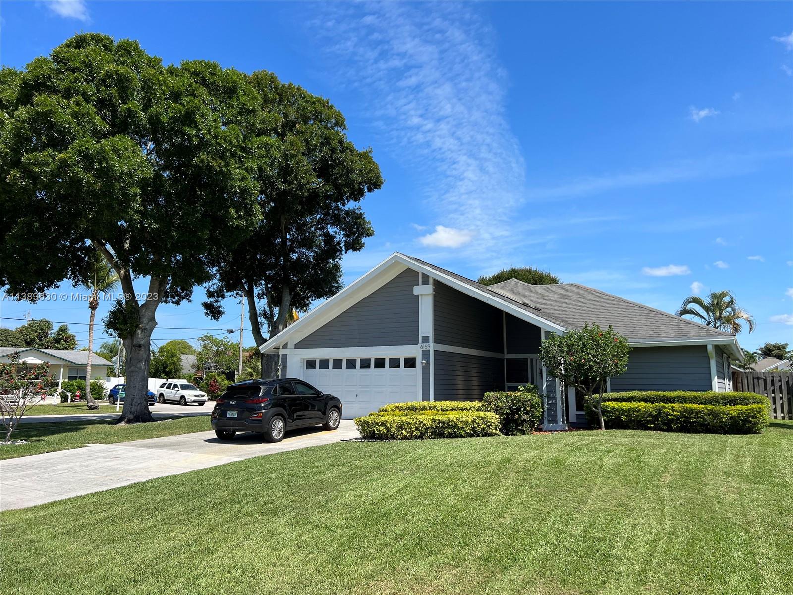 6159 Dimond Street Jupiter, FL 33458 - Photo 23 of 26 a front view of a house with a yard