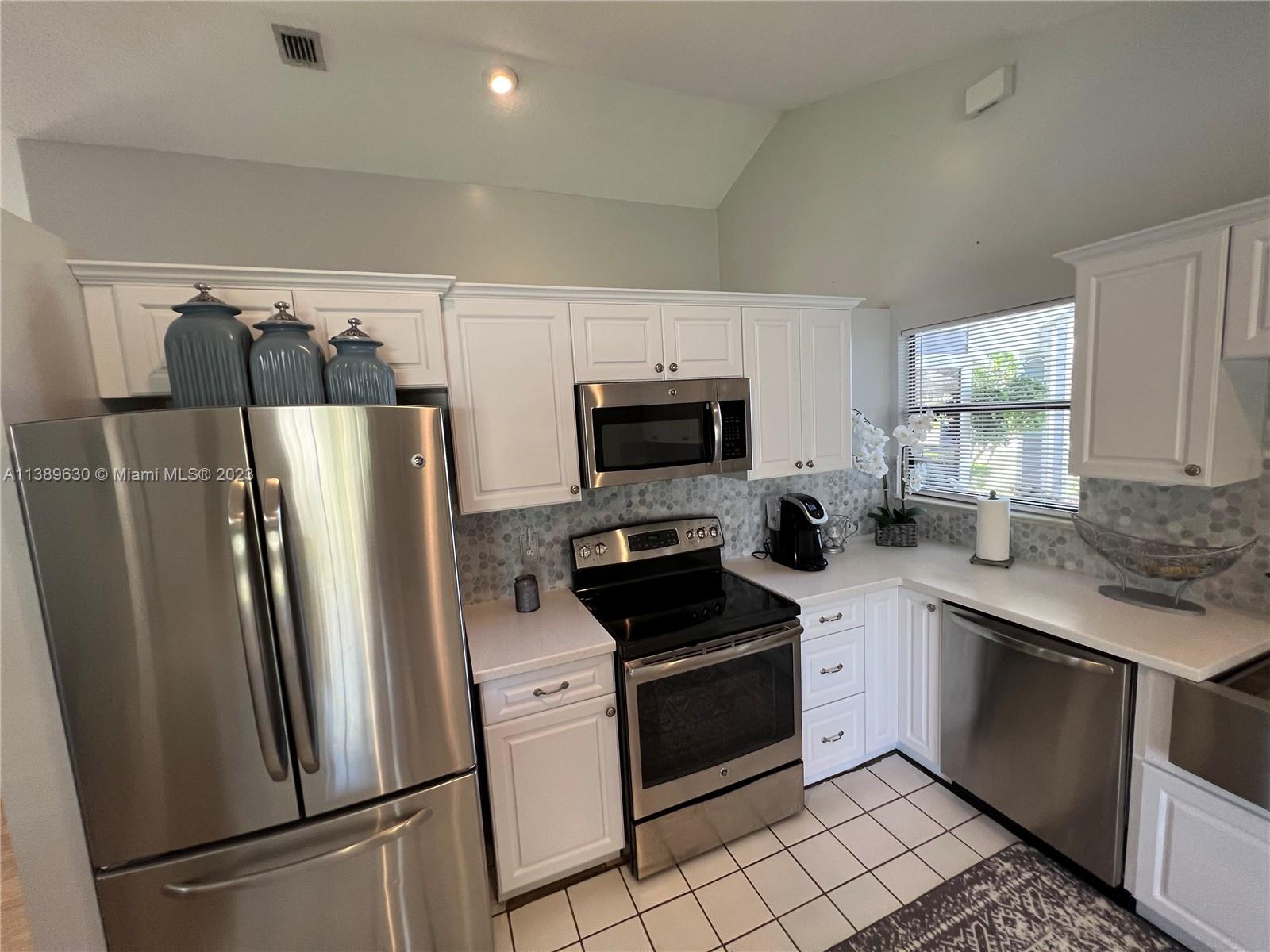 6159 Dimond Street Jupiter, FL 33458 - Photo 3 of 26 a kitchen with stainless steel appliances a refrigerator stove microwave and sink