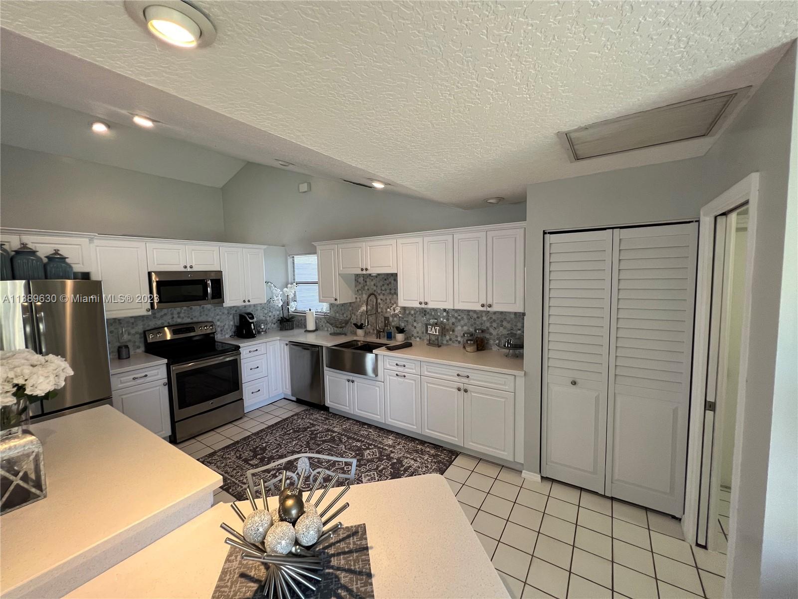 6159 Dimond Street Jupiter, FL 33458 - Photo 4 of 26 a kitchen with a sink and a stove top oven