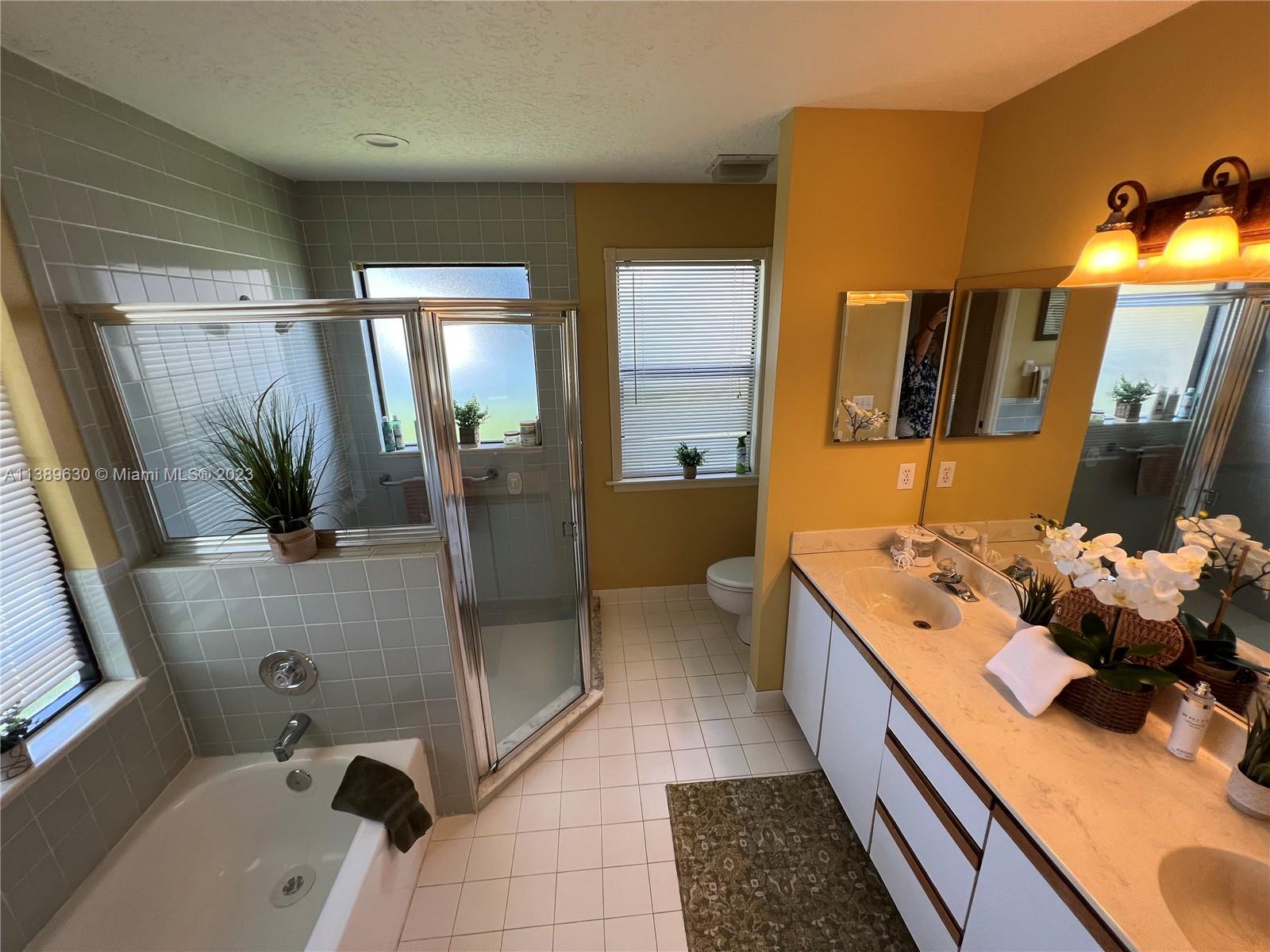 6159 Dimond Street Jupiter, FL 33458 - Photo 7 of 26 a bathroom with a tub sink and mirror