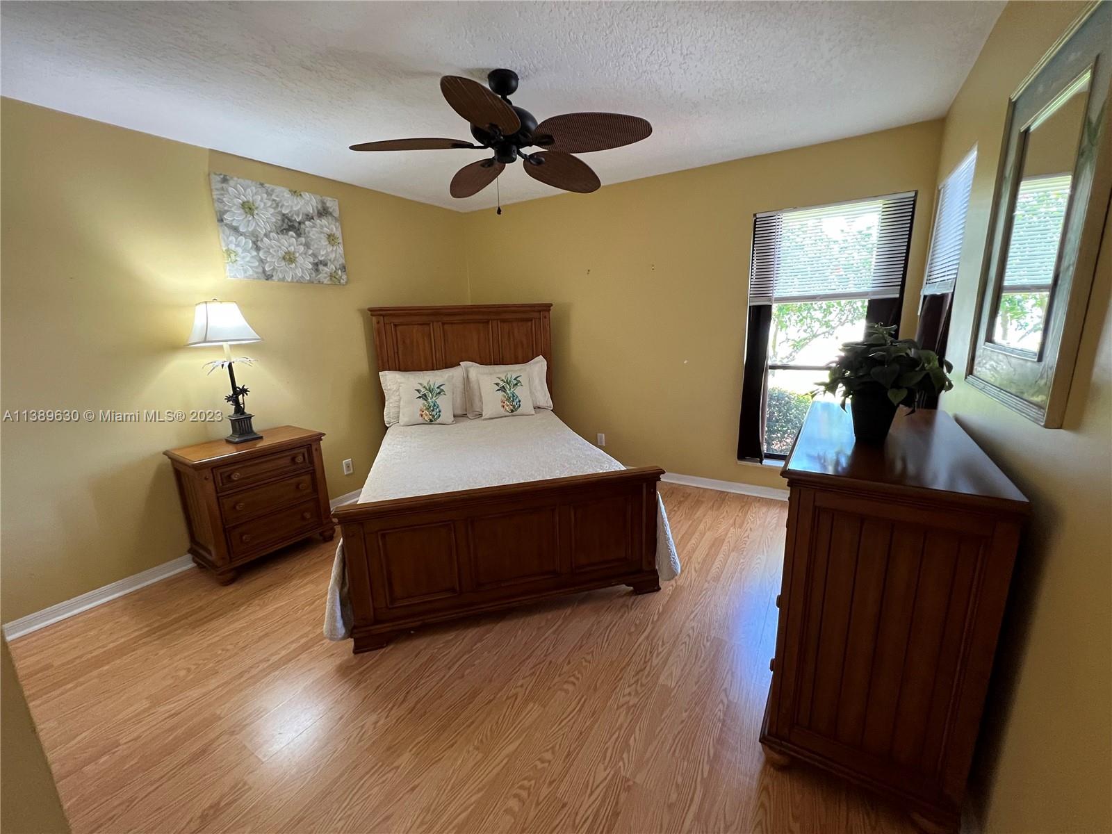 6159 Dimond Street Jupiter, FL 33458 - Photo 9 of 26 a spacious bedroom with a bed and wooden floor