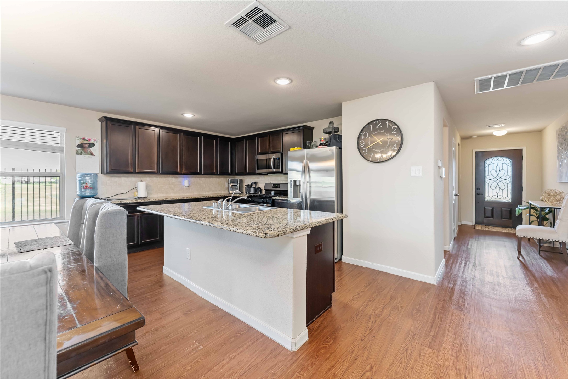 9902 Bezeled Cir Lane Rosharon, TX 77583 - Photo 5 of 29 a kitchen with stainless steel appliances granite countertop a sink stove and wooden floor