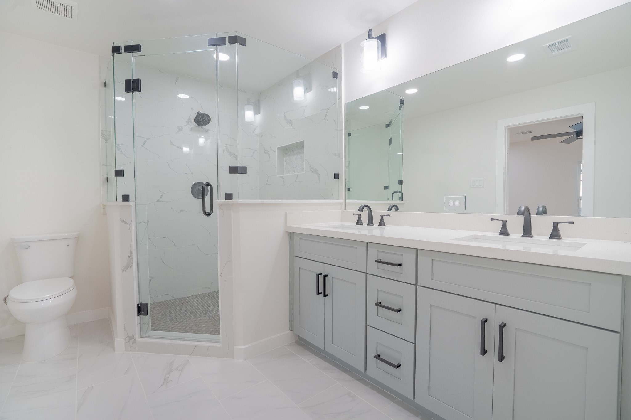1310 East 34th Street Houston, TX 77022 - Photo 17 of 19 a spacious bathroom with double sink a toilet a shower and a mirror