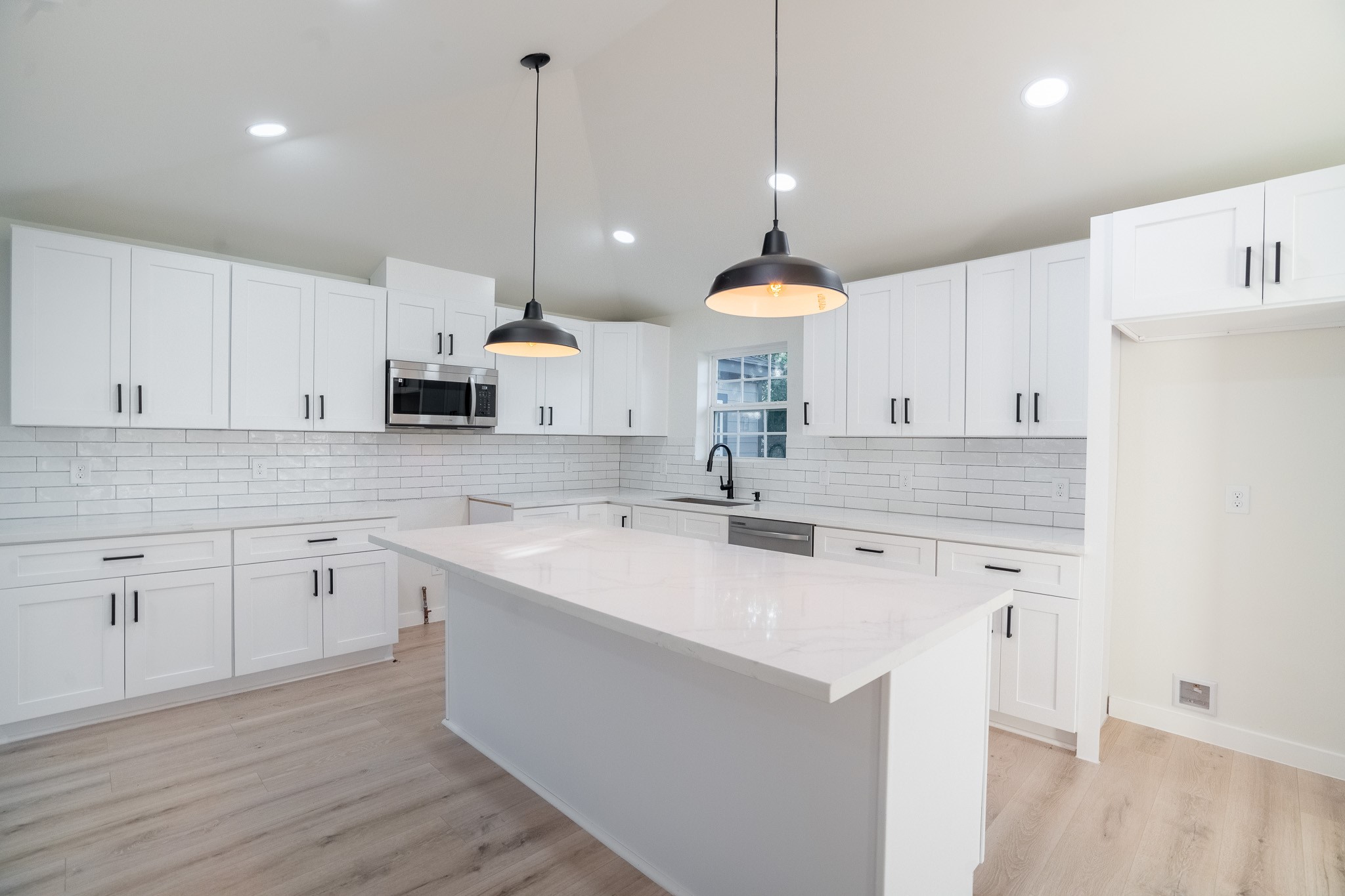 1310 East 34th Street Houston, TX 77022 - Photo 2 of 19 a kitchen with a sink a center island a counter space and cabinets