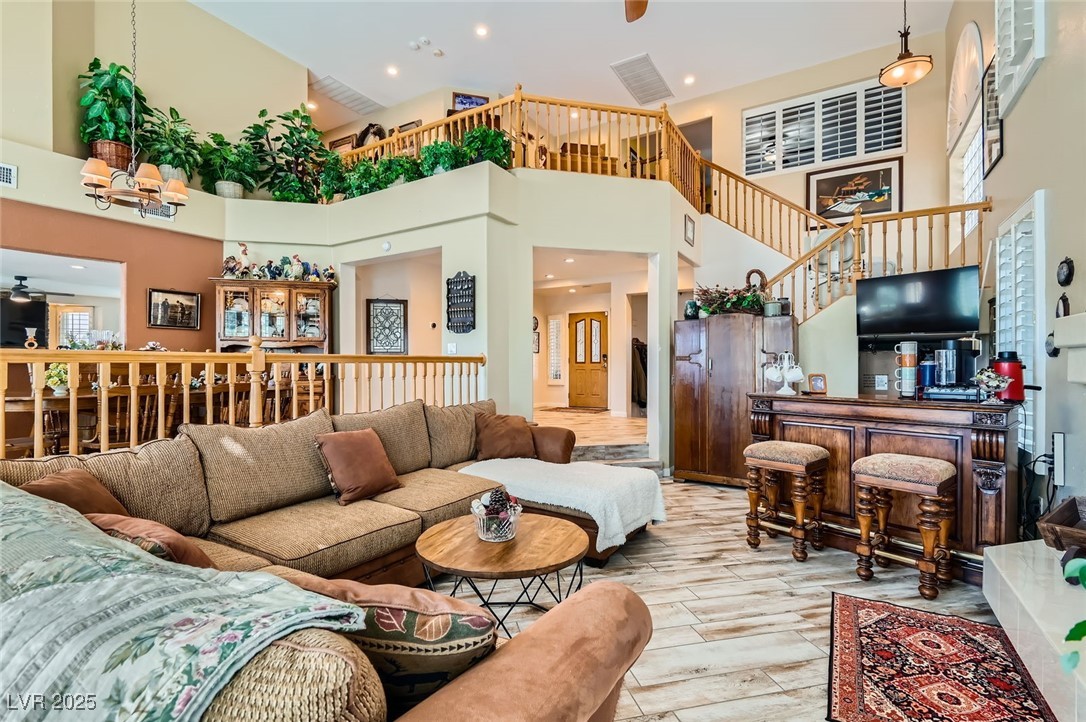 20 High Sierra Henderson, NV 89074 - Photo 11 of 53 Living room featuring wood finished floors, recessed lighting, a high ceiling, a bar, and ceiling fan