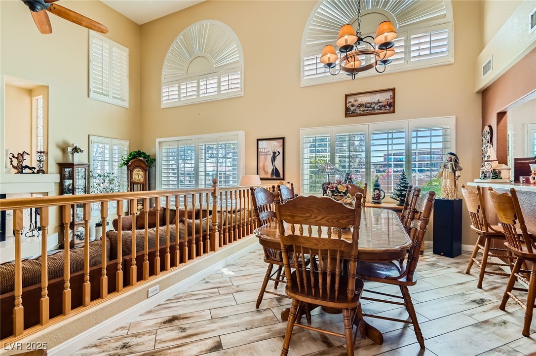 20 High Sierra Henderson, NV 89074 - Photo 17 of 53 Dining room with baseboards, visible vents, a towering ceiling, and wood tiled floor