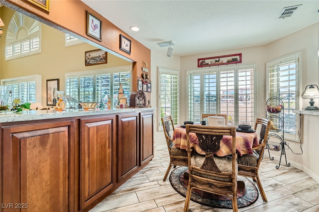 20 High Sierra Henderson, NV 89074 - Photo 22 of 53 Dining room with wood finish floors, visible vents, baseboards, and a textured ceiling
