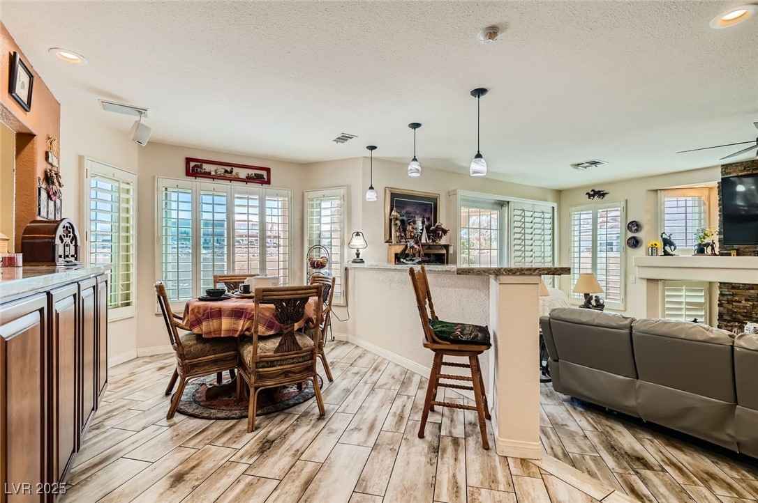 20 High Sierra Henderson, NV 89074 - Photo 23 of 53 Dining space with visible vents, baseboards, a textured ceiling, and wood tiled floor